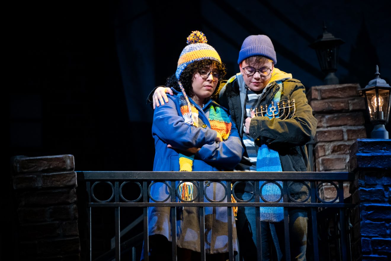<p><span style="font-size: 12.0pt; line-height: 115%; font-family: 'Aptos',sans-serif; mso-ascii-theme-font: minor-latin; mso-fareast-font-family: Aptos; mso-fareast-theme-font: minor-latin; mso-hansi-theme-font: minor-latin; mso-bidi-font-family: 'Times New Roman'; mso-bidi-theme-font: minor-bidi; mso-ansi-language: EN-US; mso-fareast-language: EN-US; mso-bidi-language: AR-SA;">Bekah Zornosa (Barb Kratzyt) and Kit Krull (Harry) </span>in <em>A Hanukkah Carol, or GELT TRIP! The Musical. </em>Photo by Margot Schulman.</p>